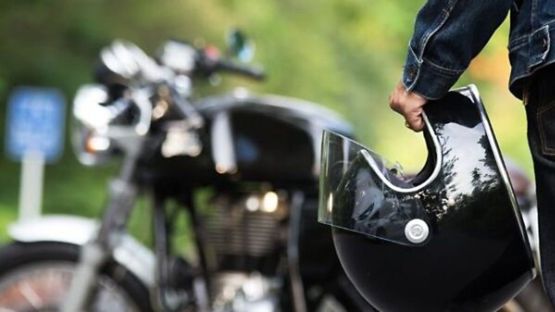 A man holding a motorcycle helmet.