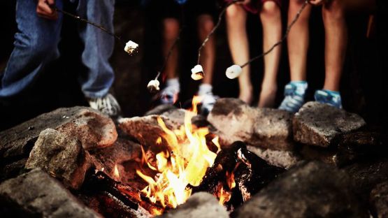 Group roasting marshmallows over an open fire