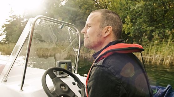 A man driving a boat on a lake.